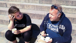 Bicca Olin och Tomas Ray samtalar på en trappa på Helsinki Pride