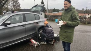 Nicklas Hägen körde ända från Åbo för att få däcken bytta, Nicklas Hägen dricker kaffe invid sin bil.