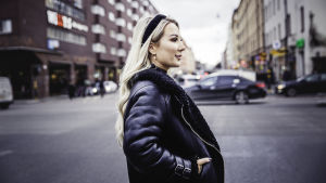 I flera år undvek hon att gå ut på stan om hon inte måste. Hon är van vid att människor stirrar på henne, värre var det när människor kunde skrika ut glåpord så fort hon lämnade sin lägenhet. Alexandra Nilsson står i profil med ansiktet riktat mot höger mitt i Stockholms centrala trafik. Hon har ett svart mjukt hårband, långt lockigt hår och en svart läderjacka på sig.