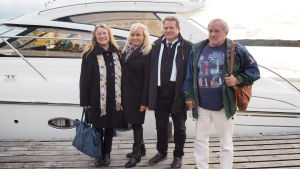 Paula Wilson, Sonja Lumme, Mikael Lumme och Peter Lumme vå kvinnor och två män står framför stor vit båt vid brygga