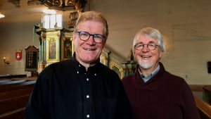 Lars-Johan Sandvik predikar och Johan Klingenberg leder gudstjänsten från Nykarleby kyrka. - Jag hoppas att gudstjänsten kan skänka ljus och hopp säger Johan Klingenberg. Lars-Johan Sandvik och Johan Klingenberg ser glada in i kameran, i bakgrunden predikstolen i Nykarleby kyrka.
