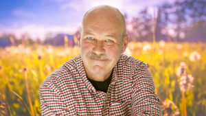 “Ju äldre jag blir, desto mera inser jag hur stor roll slumpen spelar i våra liv.” Peik Stenberg sommarpratar om slumpen. Peik Stenberg poserar på en sommaräng.