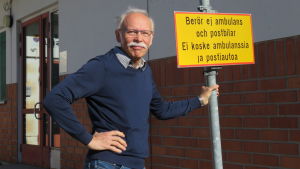 Helge Heinonen har varit Ingå trogen förutom en kort paus på drygt ett år när han specialiserade sig inom allmänmedicin och jobbade på sjukhus. En man med grått hår, mustasch och blå tröja står utanför Ingå hälsocentrals ingång. Han står och håller i en trafikskylt som förbjuder trafik, men med tillägget "berör ej ambulans och postbil".