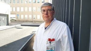 Infektionsläkare Asko Järvinen vid Helsingfors och Nylands sjukvårdsdistrikt säger att det är viktigt att patienterna för fram sina symtom och blir hörda. Asko Järvinen i läkarrock står utanför en byggnad.