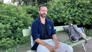 Alexander Ekman som kommit hit från Stockholm andas ut en stund utomhus utan munskydd och visir som han bär under repetitionerna på Nationalbaletten. Koreografen Alexander Ekman sitter på en bänk.