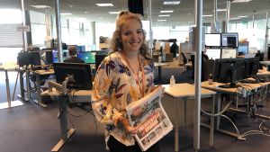 Fanny Fröman har producerat barnnyheter för Helsingin Sanomat sedan 2016. En ung leende kvinna vid en nyhetsredaktion.