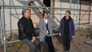Magnus Sundman, Anne Bergström och Lena Långbacka ser framemot branddepåns utställning. En man och två kvinnor vid ett hus som renoveras.