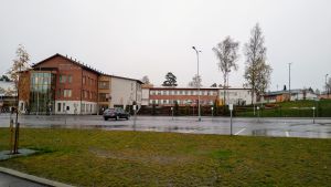 Korsholms högstadium. I bakgrunden syns en stor skola, framför finns en tom parkeringsplats med endast en bil.