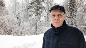 Någon egentlig analys av hela försvarets behov gjordes inte i samband med utredningen inför jaktplansanskaffningarna, säger den pensionerade översten Ahti Lappi. Ahti Lappi, i svarta vinterkläder med snöklädda träd i bakgrunden, småler.
