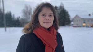 Anita Sundman (SFP) har efter långt övervägande bestämt sig för att ställa upp för omval i Korsholm. Hon upplevde kommunens hätska fusionsdebatt som tung, men säger att beslutsfattarna nu har lagt det hela bakom sig. Kvinna med ytterrock och roströd halsduk står ute i vintrigt landskap. Tittar leende in i kameran.