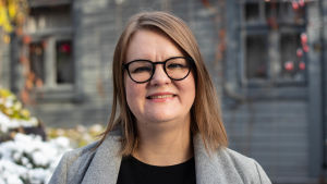 Tiina Ristikari är utvecklingsdirektör på Självständighetsjubileets barnstiftelse Itla och specialforskare vid Institutet för hälsa och välfärd THL. Hon efterlyser konsekvensbedömning för hur pandemibesluten påverkar barn och unga. Kvinna i utomhusmiljö tittar in i kameran och ler.
