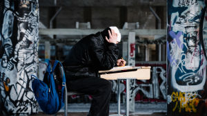 Enligt Yles granskning var pojken utsatt för mobbning i skolan. Illustrerande arkivbild. kuvituskuva nuori istuu yksin pulpetin ääressä graffitien ympäröimänä