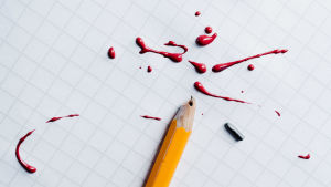 En grundlig granskning som Yle har genomfört visar att offret inte fått det stöd han hade behövt. Illustrerande arkivbild. kuvituskuva katkennut lyijykynä ja punaista väriä ruutuvihkon päällä