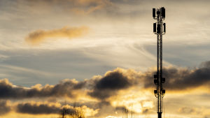 Den nya och snabbare 5G-tekniken erbjuds främst i storstäderna och lyser ännu med sin frånvaro på glesbygden. En basstation för bredband mot en gul och molnig himmel.