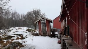 Själö bjuder på överraskningar. En rödmålad utetoalett lutar på en snöig bakgård på Själö.
