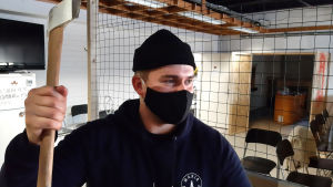 Christoffer Zitting lättar på stressen i ilskrummet. En man i blått står med en yxa i handen.
