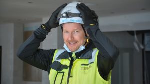 Arttu Hirvonen visade pressen runt i det nya hotellet. Men med reflexväst och hjälm vid byggplats.