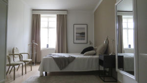 Väggarna är målade i ljusa och diskreta färger. Sovrummen ser alla ganska lika ut. Ett sovrum i ett tidigare äldreboende. Ser mera ut som ett hotellrum.