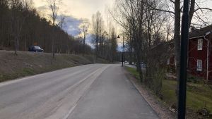 Samma område i verkligheten. På fotot börjar området för bostäder och affärsverksamhet uppe till vänster,ungefär från bilen som syns. En vy från Bruksvägen i Billnäs bruk, till höger gamla bruksbostäder, till vänster Banvallens cykelled.