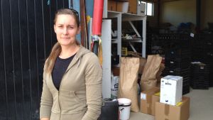 Micaela Ström hjälper lantbrukare som vill lära sig odla ekologiskt. kvinna i dörr till lager.