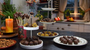Ett bord dukat med olika julgodis, chokladpraliner och cake-pops - en sorts småkaka på pinne.
