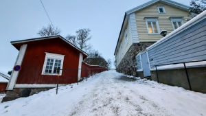 Här kommer man inte ner utan att få en liten adrenalinkick. En brant backe kantad av ett rött och ett gult trähus. Backen är täckt av is och snö men sandad.