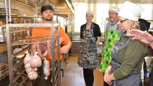 Slaktmästare Sven Lindauer berättar om korvtillverkning för Karolina Jensen, Iniö, Sten Öhman, Hangö och Magdalena Ek, Nagu. Slaktmästare Sven Lindauer från Tyskland berättar om korvar.