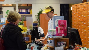 Nej, inte en skogshuggare utan en farmaceut. Utrustad med skyddsvisir klarar farmaceut Micael Qvarnström jobbet med mindre smittorisk. Farmaceut Micael Qvarnström iförd skyddsvisir betjänar en kund.