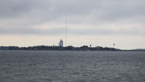 Området längst ut på udden ägs av statliga Senatsfastigheter. Udde med ett torn och en mast, en kitesurfare i förgrunden.