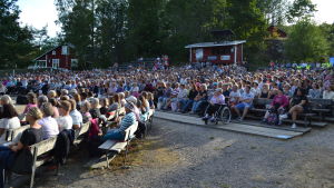 Raseborgs sommarteater är en stor publikmagnet i västra Nyland. West Side Story år 2018 hade nästan 14 000 åskådare. Frågan är om det är tryggt att ordna så stora publiktillställningar i sommar. Publik sitter på läktare utomhus. Det är fullsatt och det ryms ungefär 1000 personer där. I bakgrunden syns hus och träd.
