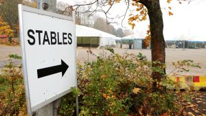 Raderna av tältstall på ishallens parkeringsplats. Skylt vid Helsingfors ishall som det står Stables på.