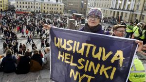 Demonstrant med plakat på klimatmarschen i Helsingfors.