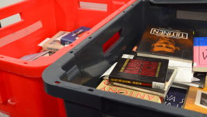 Borde fler böcker bli kvar i de bibliotek där de lämnas in? Lådor med biblioteksböcker för transport till Helle-bibliotek.