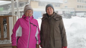 Ilse Hellström och Anna-Lisa Rosenqvist är med i olika pensionärsföreningar på samma lilla ort. Ilse Hellström och Anna-Lisa Rosenqvist står i snöfall invid Dalsbruks torg