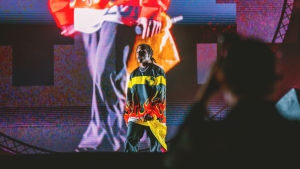 Kesän 2019 tapahtumien vuoksi Asap Rocky on nyt tunnetumpi kuin koskaan aiemmin. Räppäri Asap Rocky Blockfest-lavalla. Päällä räppärillä on keltamustapunainen liekkipaita, taustalla näkyy hänen kuvansa suurena screenillä.