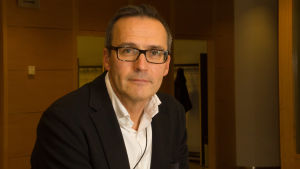 Mikko Kautto Porträttbild av Mikko Kautto iklädd kavaj, vitskjorta och glasögon.
