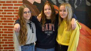 Malin, Matilda och Anna skulle hellre se att hög- och lågstadierna låg i skilda skolor. Tre flickor poserar framför en vägg med färggrann målning.