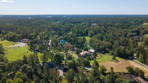 Fram till 1977 var Snappertuna en kommun, den sista enspråkigt svenska kommunen i Nyland. en drönarbild på snappertuna by. Mycket skog, några hus.