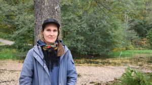 Chia Näsman har haft ett hektiskt första år. Efterfrågan är större än än vad hon hinner producera. Hon planerar att utvidga i sakta mak och köpa några maskiner eftersom hon inte hinner skära alla morötter för hand. Kvinna klädd i blått, i bakgrunden ett vattendrag.