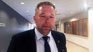 Det var som vi befarade. Nu har vi varken insyn eller möjlighet att inverka mera på vilken service som i framtiden ges på Åbolands sjukhus, sa Niklas Guseff efter mötet. Niklas Guseff står i en korridor.