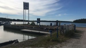 De nya företagarna ska redan på måndag piffa upp stället. bensinpumpen invid pargas gästman i solsken. Några övertäcktabensinpumpar syns och hav i bakgrunden.