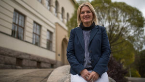 Maarit Söderlund, bildningschef i Kristinestad. Arkivbild. kvinna sitter på sten framför gammal byggnad