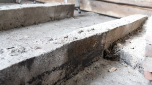 Kreosotbitum skyddade betongbalkarna mellan källaren och första våningen – ännu finns spår av det svarta ämnet. Betonggolv, ett ställe av betongytan är svart.