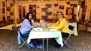 Juraj Duna missionerar tillsammans med kollegan Iuga Paulina. Två människor sitter mittemot varandra vid ett bord i ett gult tält.