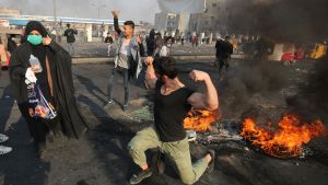 En av demonstranterna på Tayaran-torget passade på att spänna musklerna mitt bland de brinnande bildäcken. En av demonstranterna på Tayaran-torget passade på att spänna musklerna mitt bland de brinnande bildäcken.