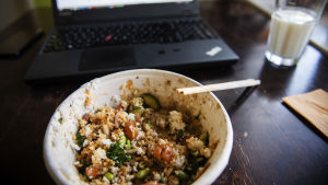 Stanna hemma, eller ät åtminstone inte i personalmatsalen ifall appen varnar om möjlig smitta. Kuvassa on poke bowl -ruoka-annos lohella ja riisillä keittiön pöydällä.