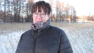 Naturfotograf Satu Wikström upplevde ett unikt naturögonblick tillsammans med två uttrar invid Baggö bro i Ekenäs. Kvinna står vid vintrig strand