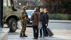 Fotgängare pratar med en soldat i Bryssel efter terrorattackerna den 22 mars 2016.