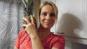 Susanne Strömberg använder nyttiga råvaror i matlagningen. Bild på Susanne Strömberg tillsammans med en ananas.