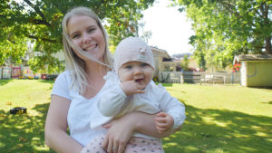 En bild på en kvinna med en bebis i famnen. Hon heter Linn Wassström-Måsabacka och dottern Elle Måsabacka.